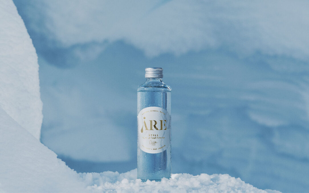 Close-up of an Åre water bottle in snow, showcasing the product in a snowy landscape.